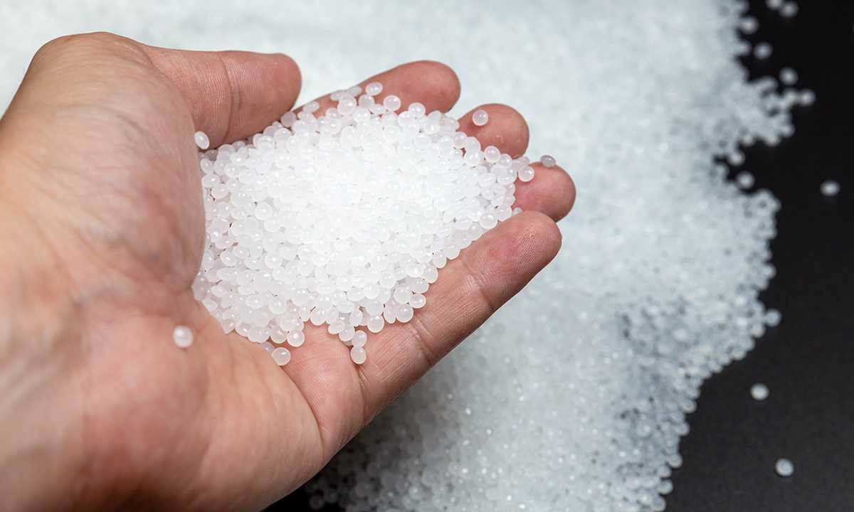 Hand håller plastpellets